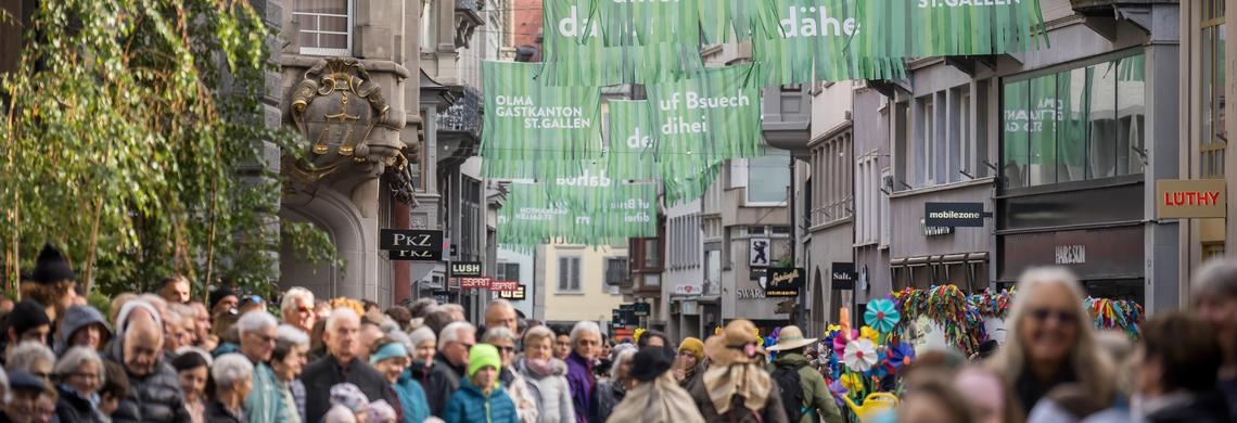 Die Multergasse ist mit den Fahnen des Gastkantonsauftritts geschmückt. Am Tag des Umzugs stehen viele Leute in der Gasse.